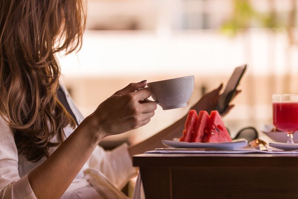 Vogal Luxury Beach Hotel & Spa Natal Exterior foto A woman drinking coffee